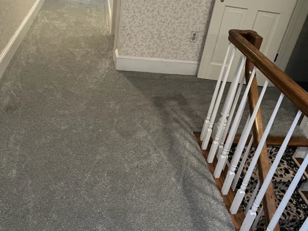 Completed grey carpet installation on a hallway and staircase