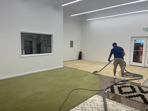 Technician vacuuming an area rug in the rug cleaning facility