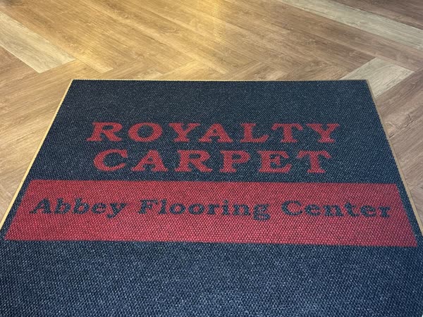 Royalty Carpet branded entrance mat on herringbone flooring in the showroom